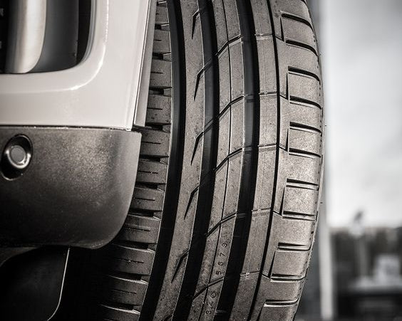 Primer plano de un neumático Bridgestone de auto, mostrando su textura y diseño detallado.