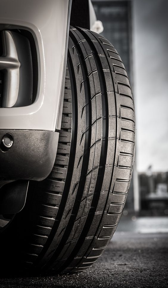 Primer plano de un neumático Bridgestone de auto, mostrando su textura y diseño detallado.